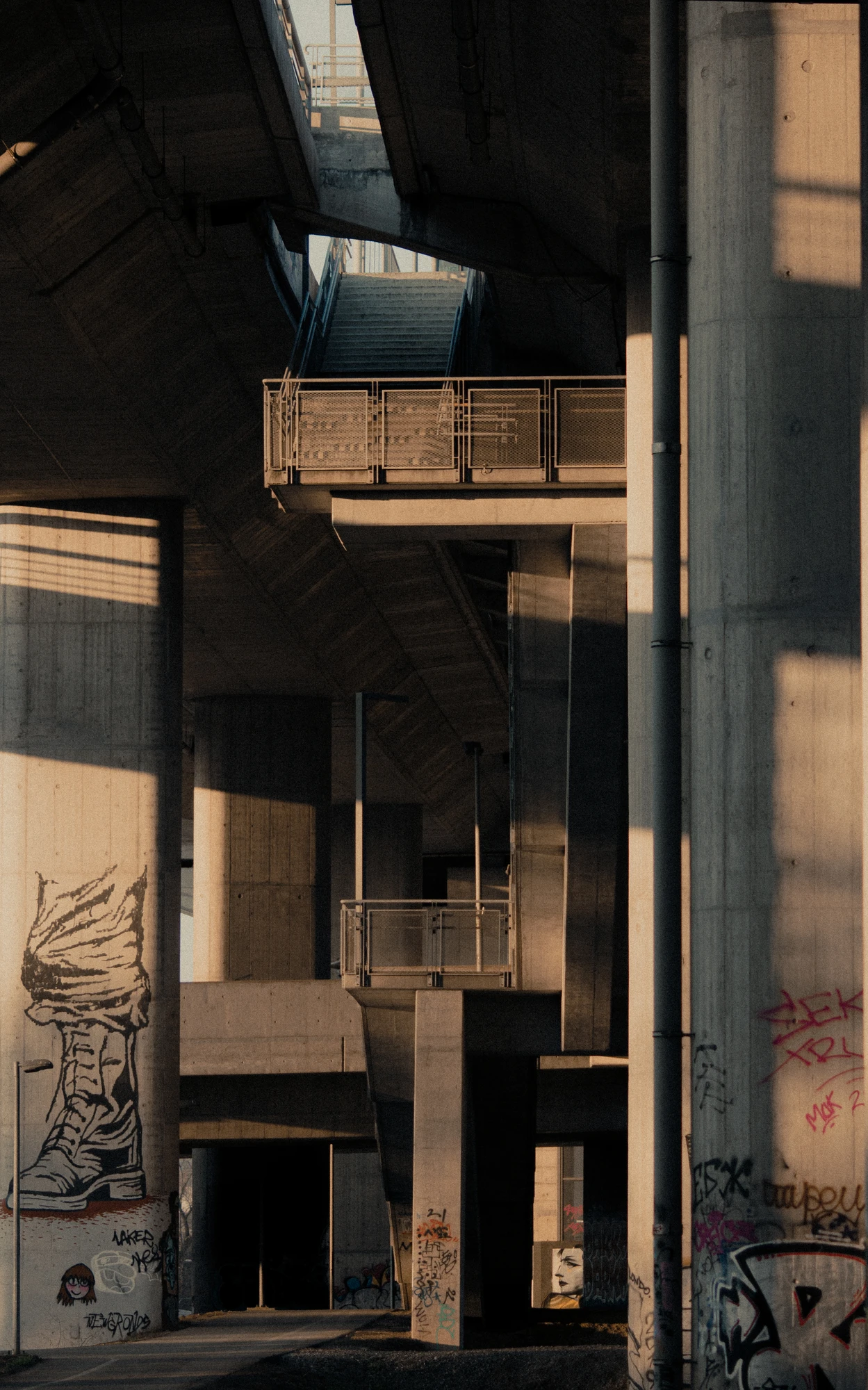 Multi-level concrete underpass with graffiti on support pillars