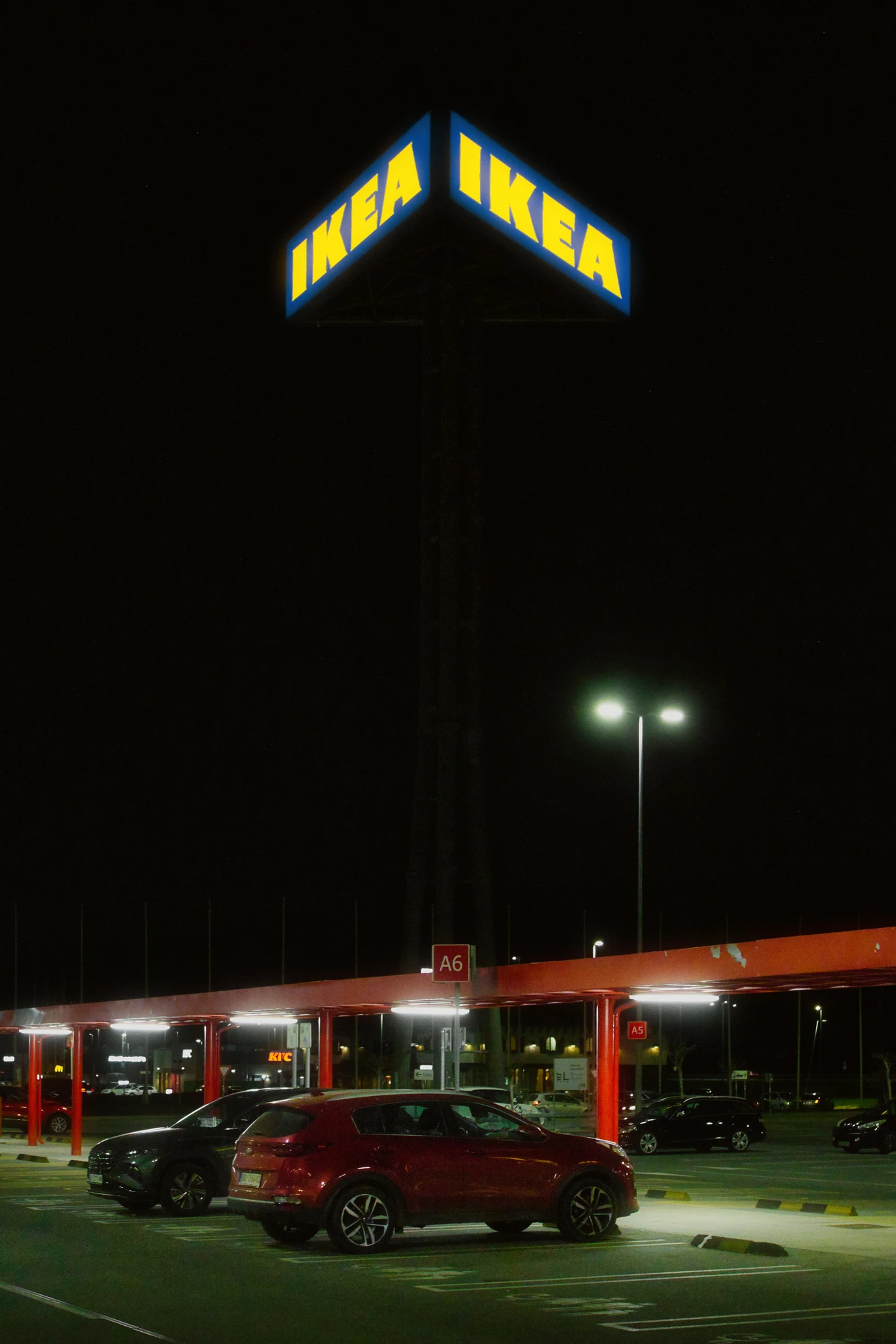 A view of a car park at night with a sign above it