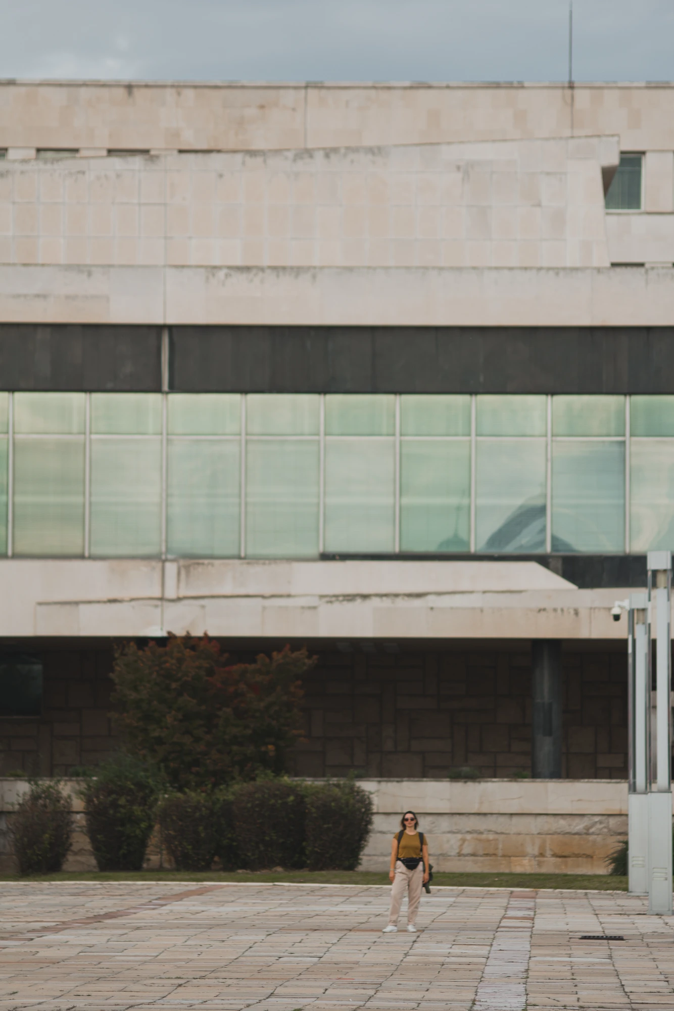 A girl standing in front of a huge concrete palace