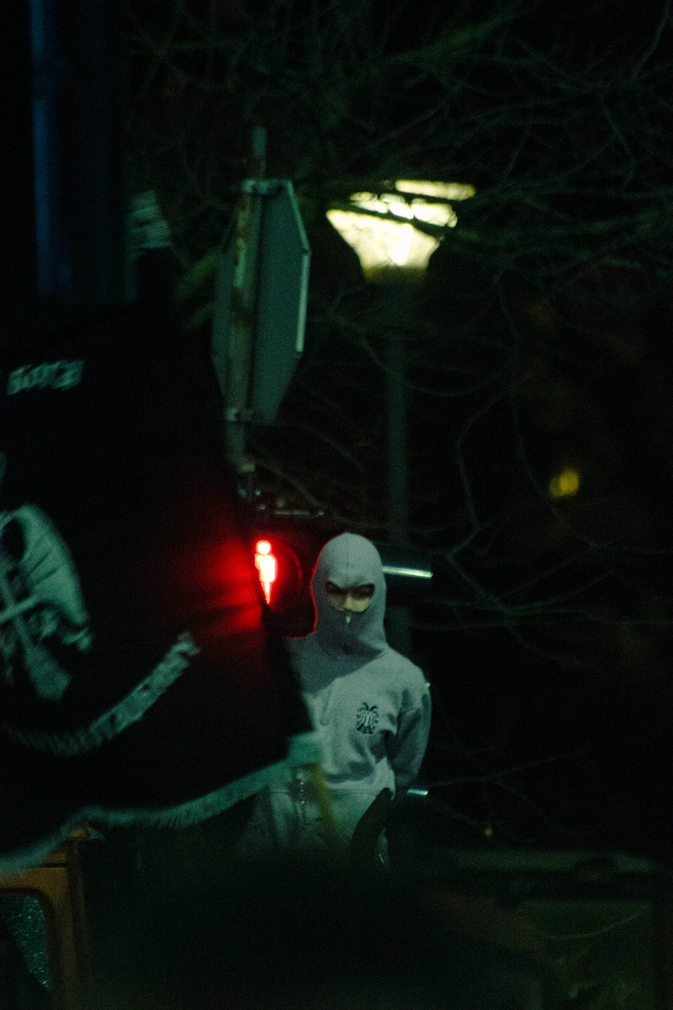 A young rioter with a phantom hoodie waving a flag at night