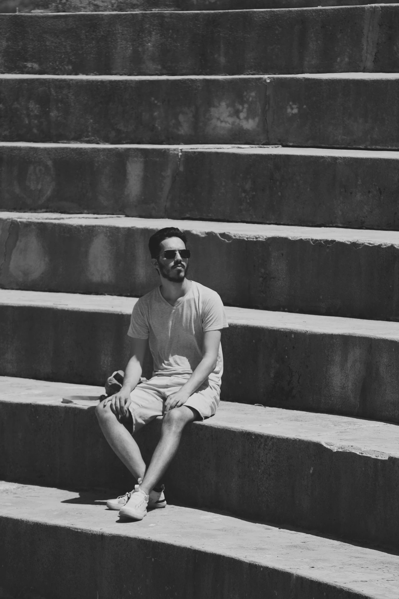 A person with sunglasses sitting on amphitheatre stairs