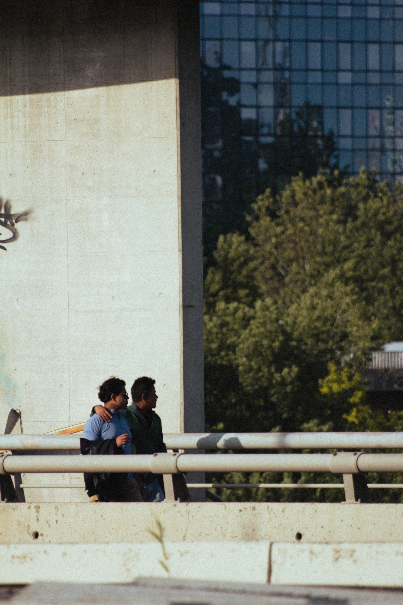 Two people walking on a bridge