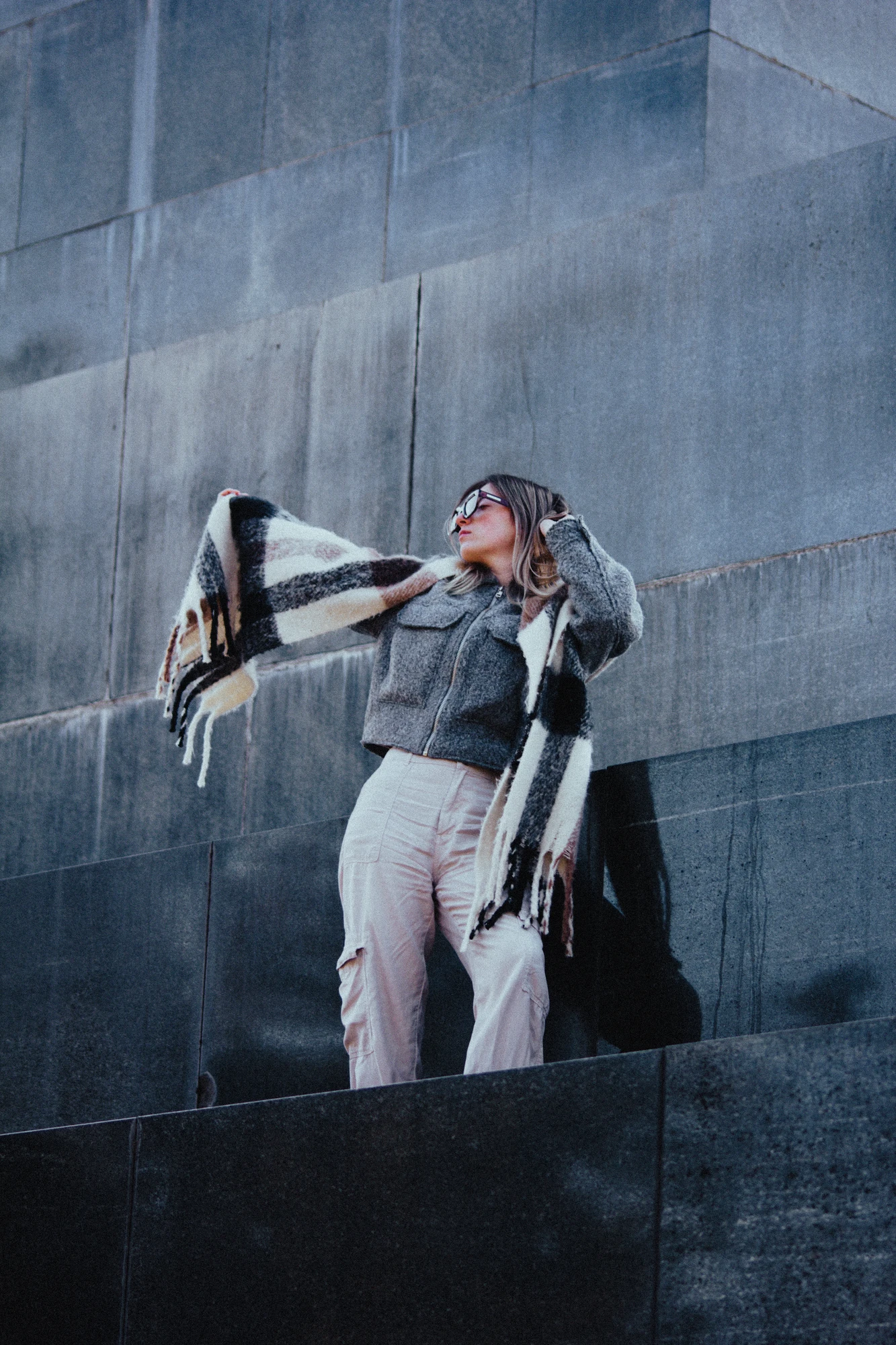 Woman standing on a black marble monument with a scarf over her shoulders
