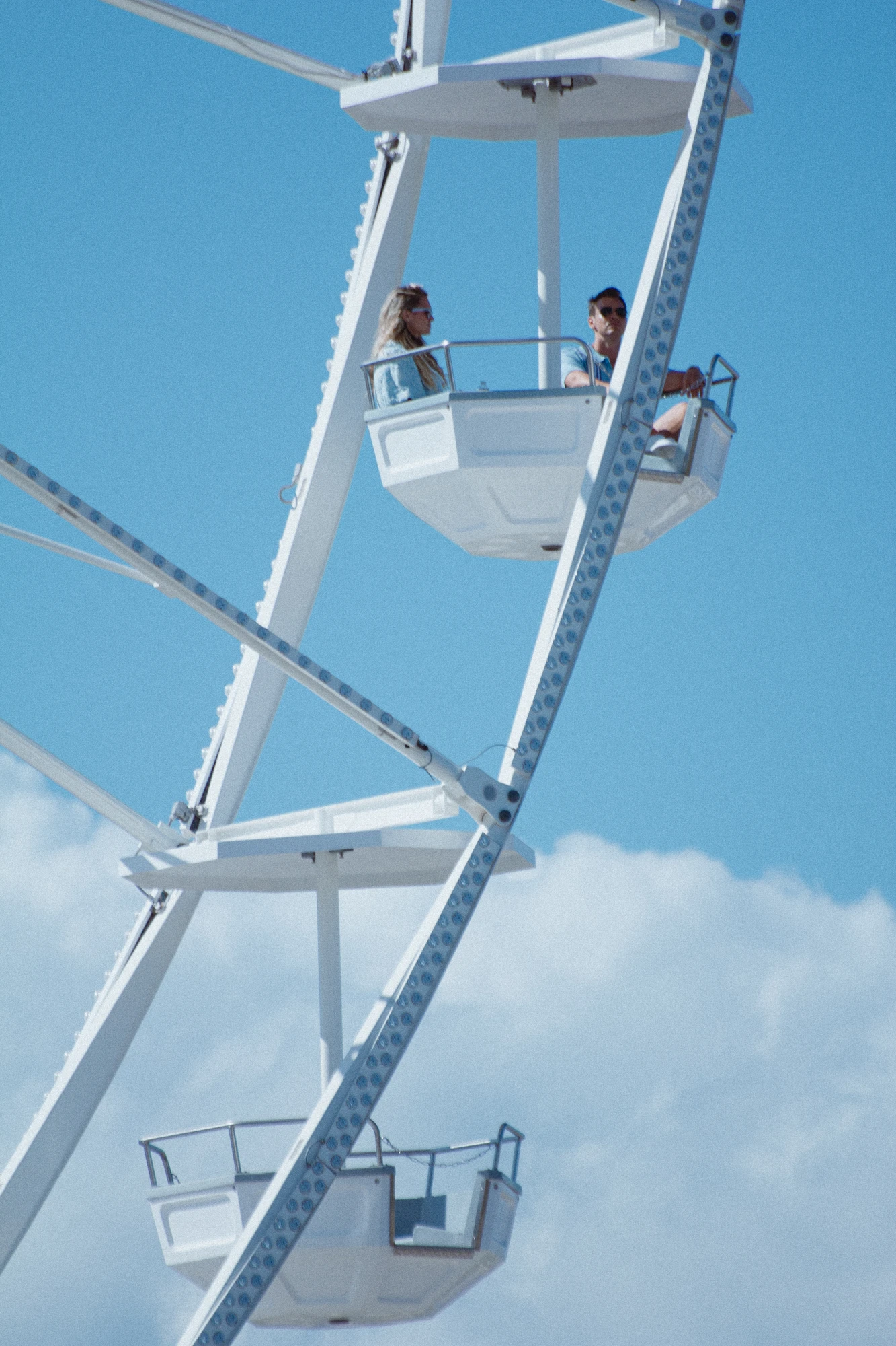 Two people sitting on a ferris wheel in the sky