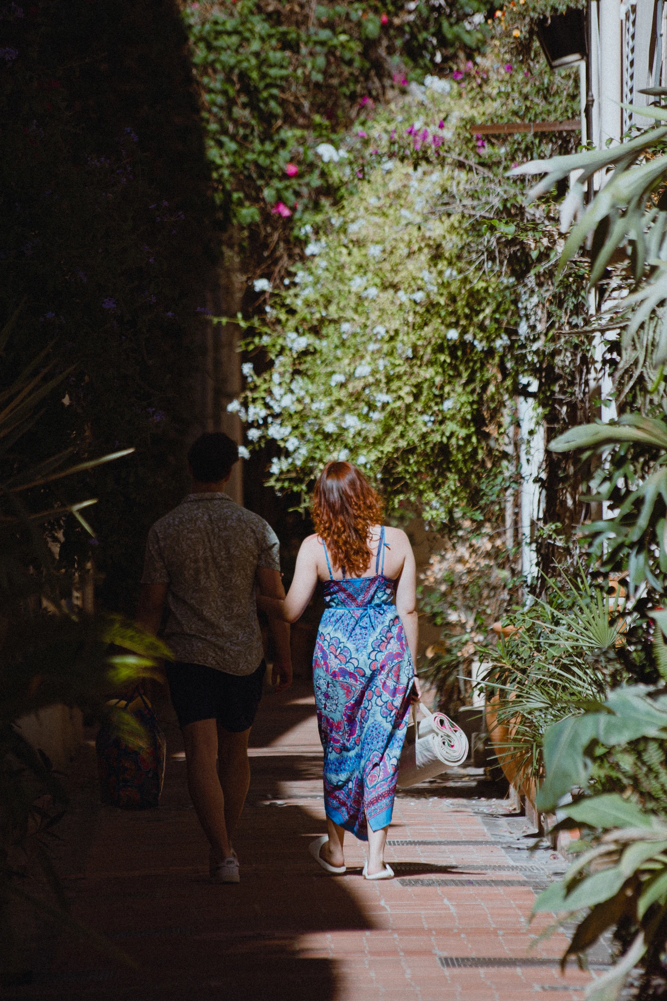 Two people walking down a narrow alley way