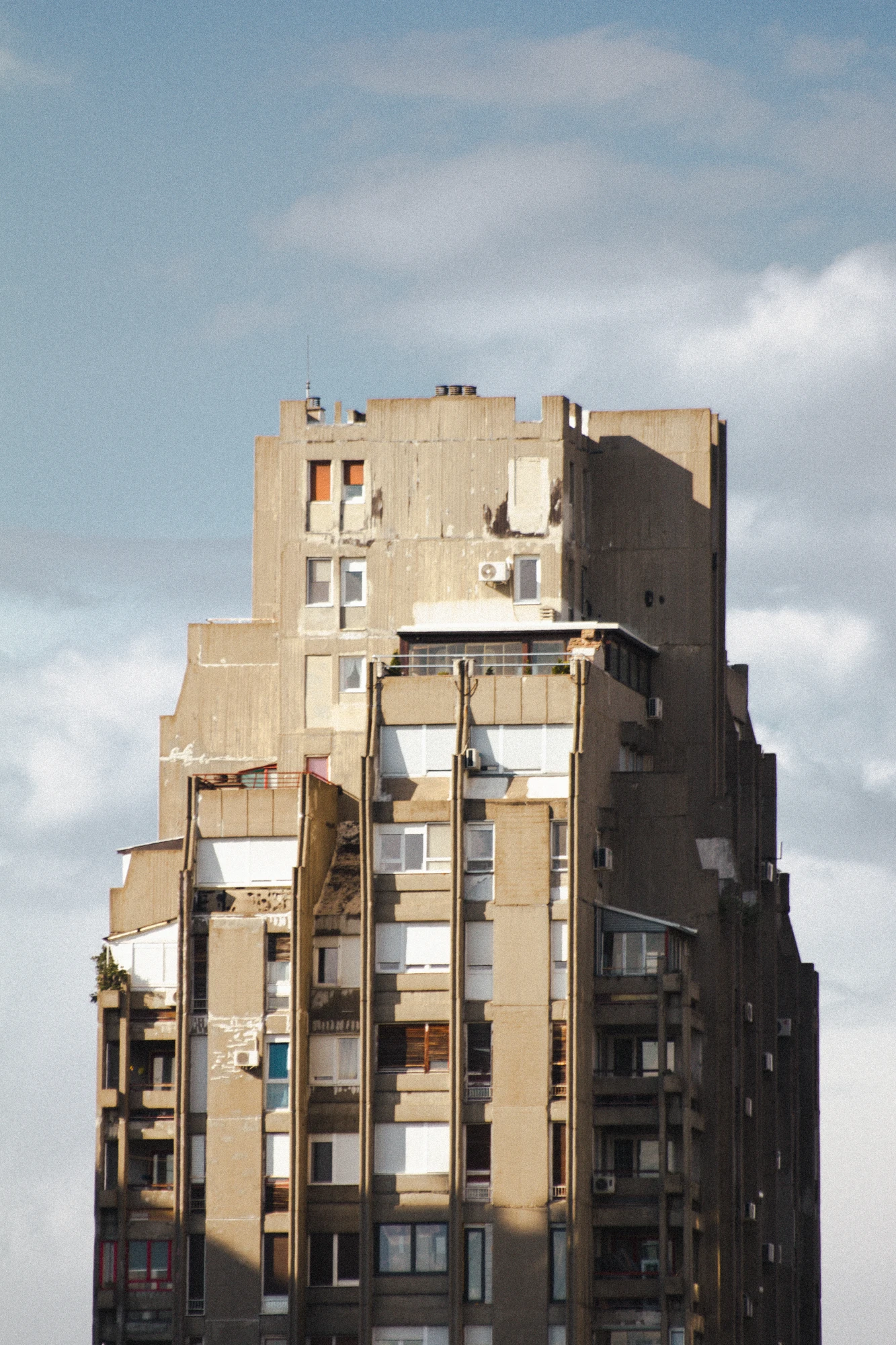 A huge concrete skyscraper with many windows