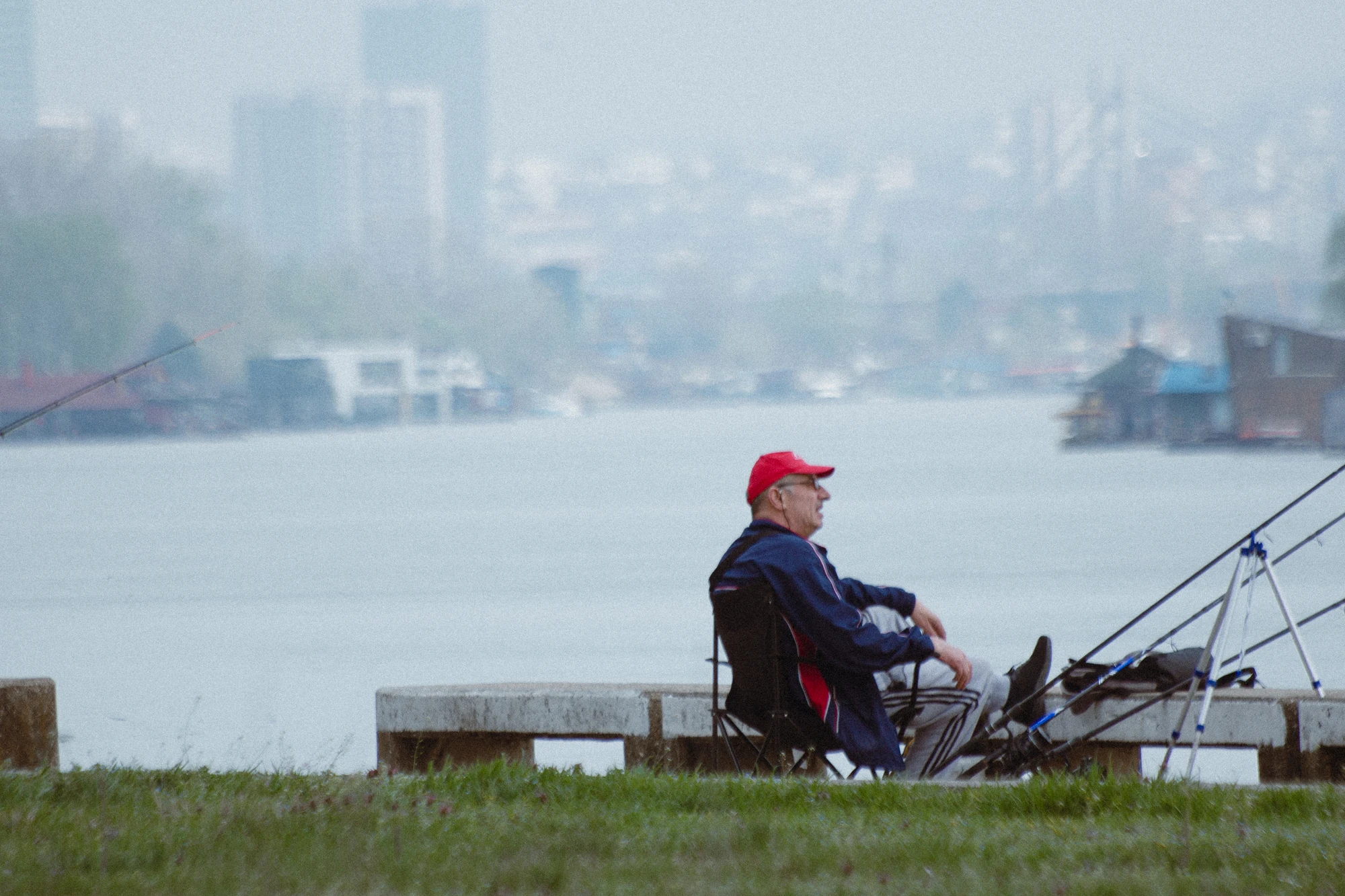 A man sitting on a bench with a fishing rod