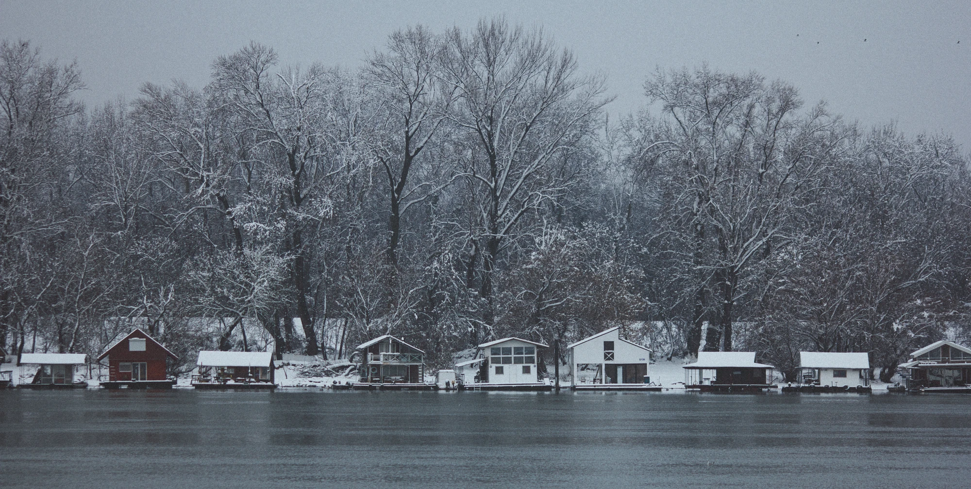 Raft-houses on a river bank in the snow