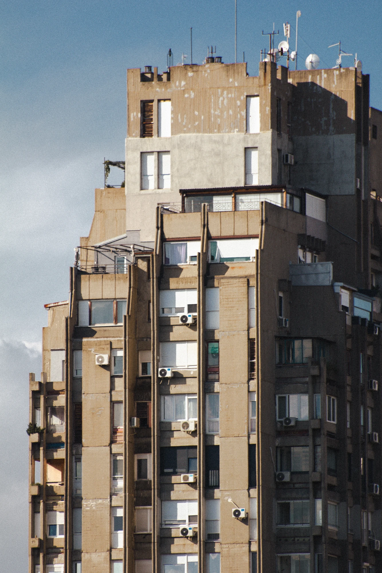 A huge concrete skyscraper with many windows