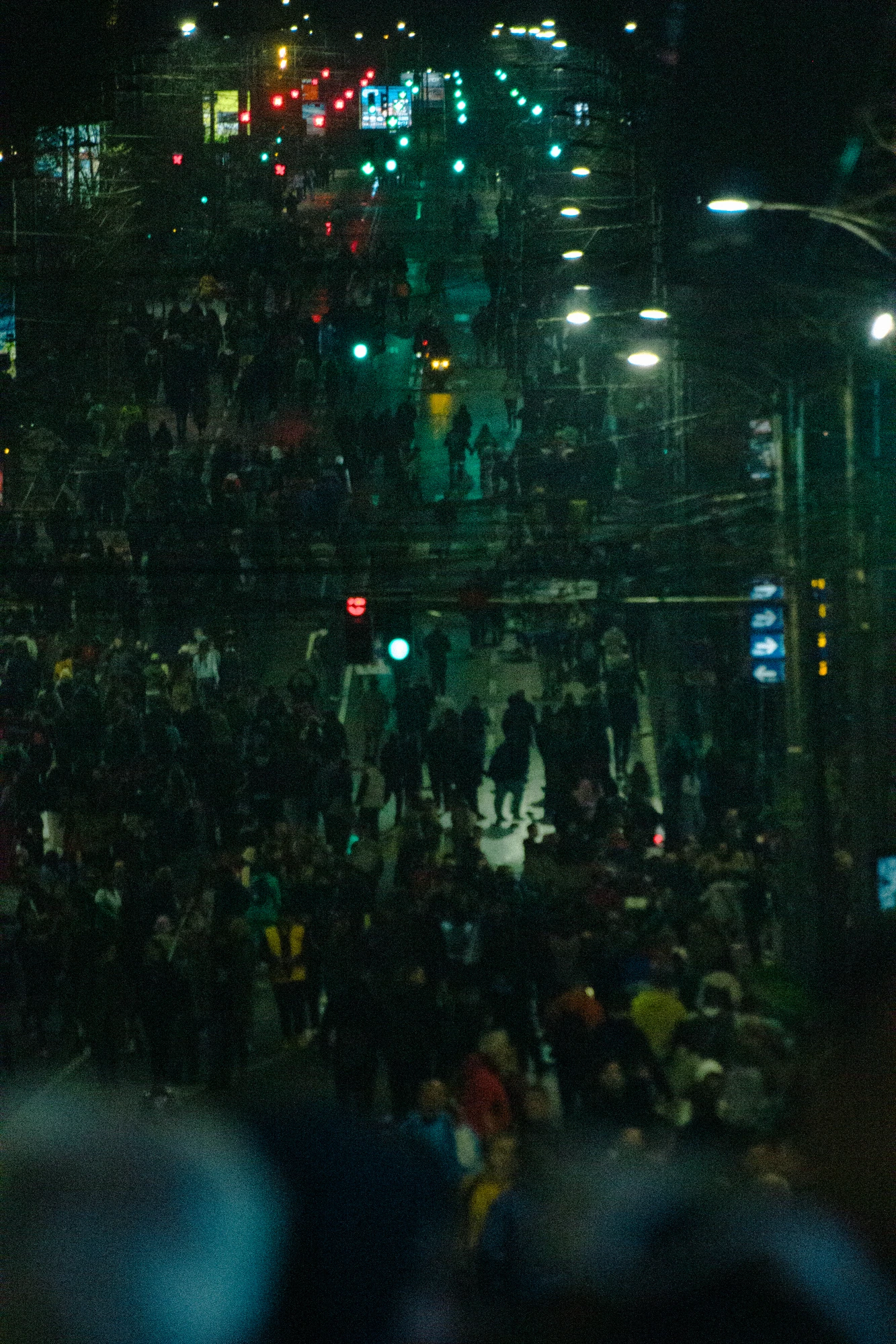 Many people walking down the street at night