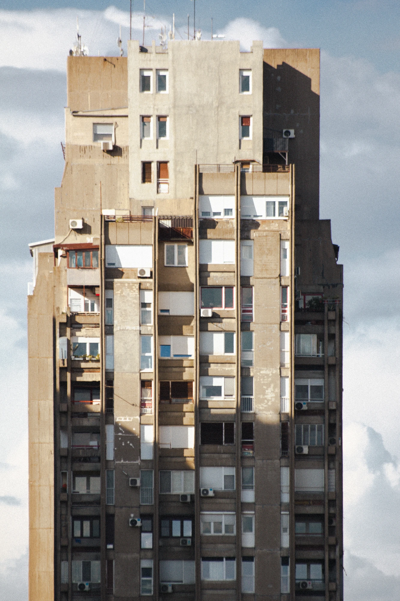 A huge concrete skyscraper with many windows