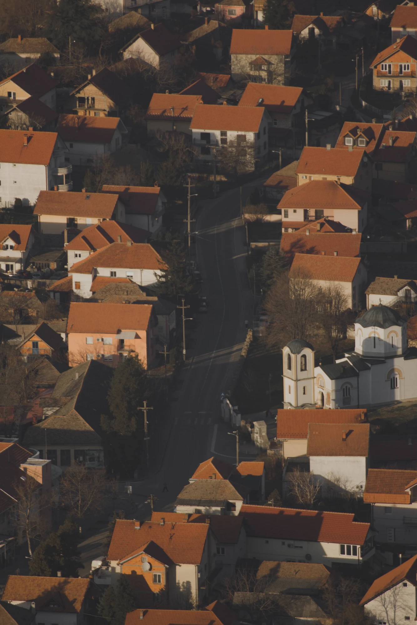 A street going through an area with red tile roof houses