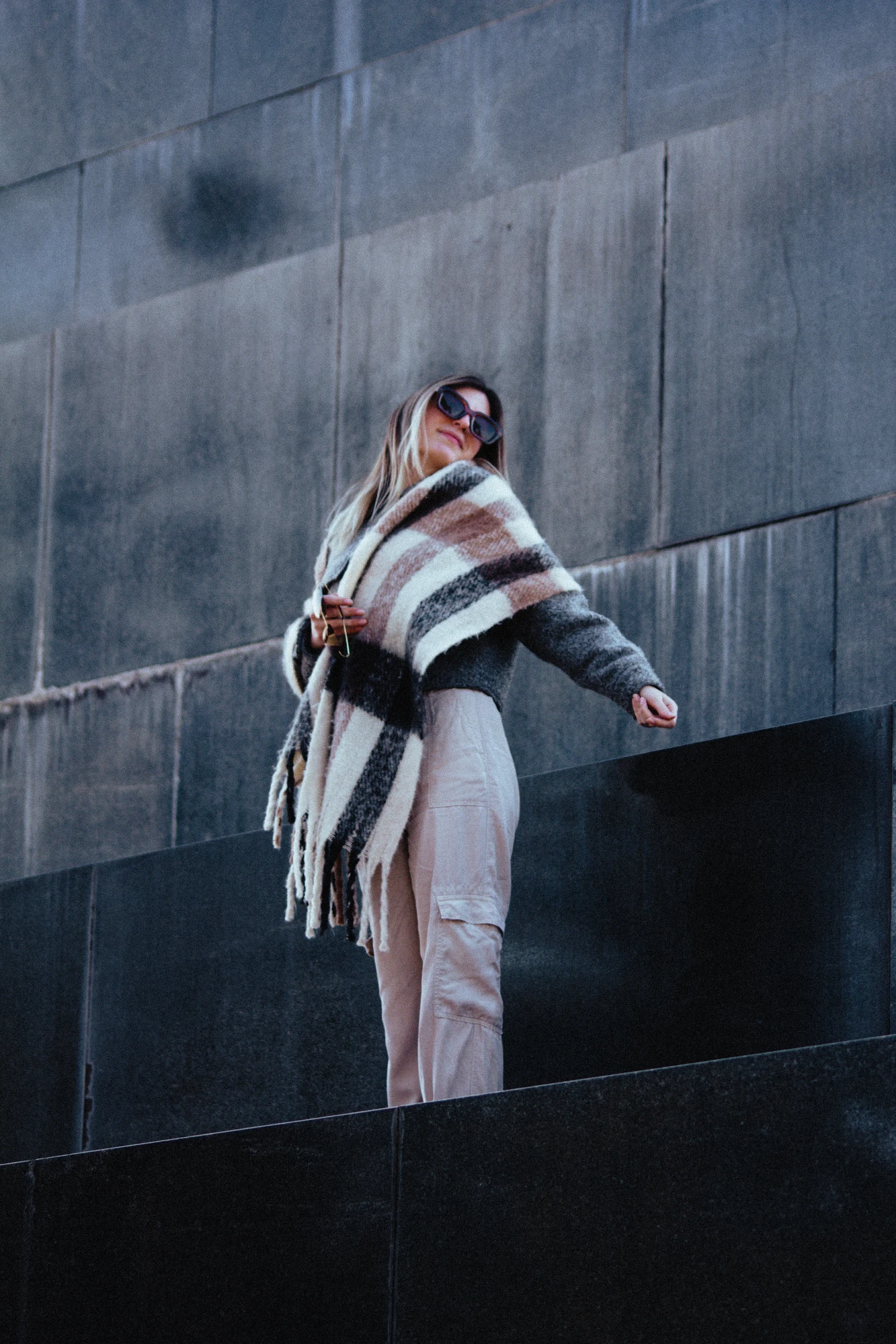 Woman standing on a black marble monument with a scarf over her shoulders