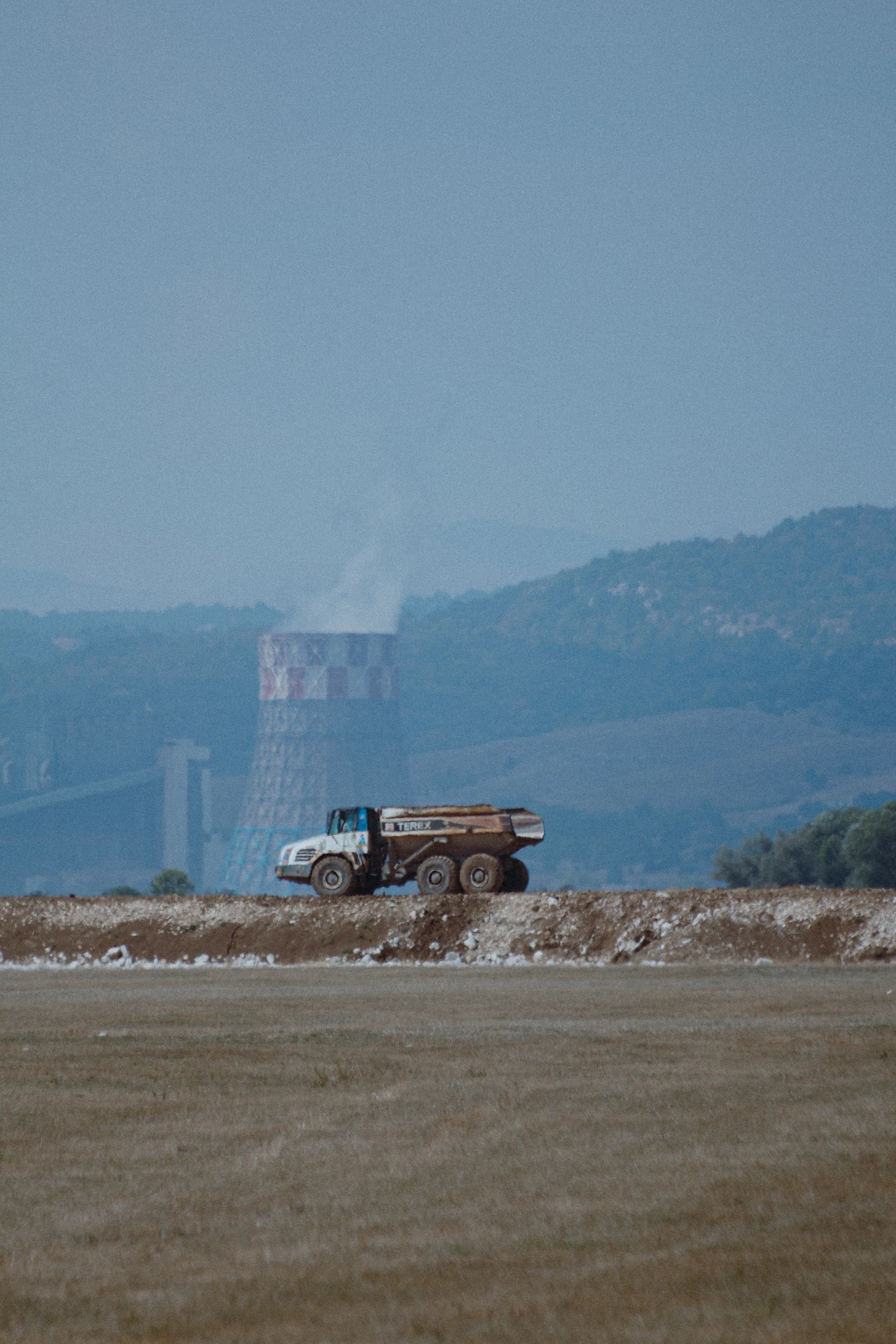 A truck with a power plant in the background