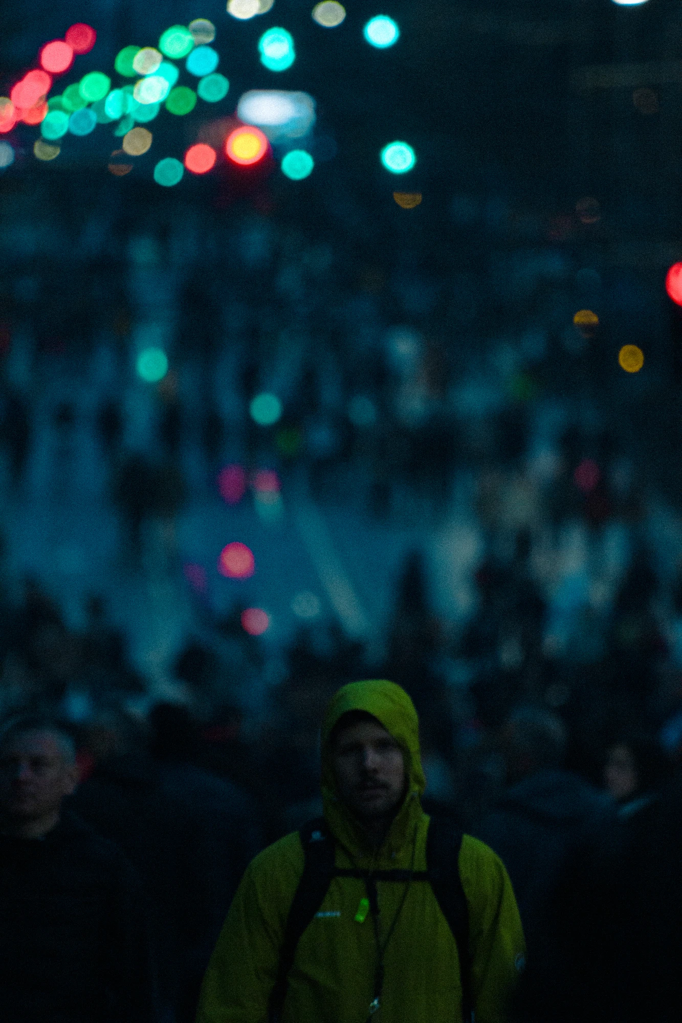 A man in a yellow jacket standing in a crowd