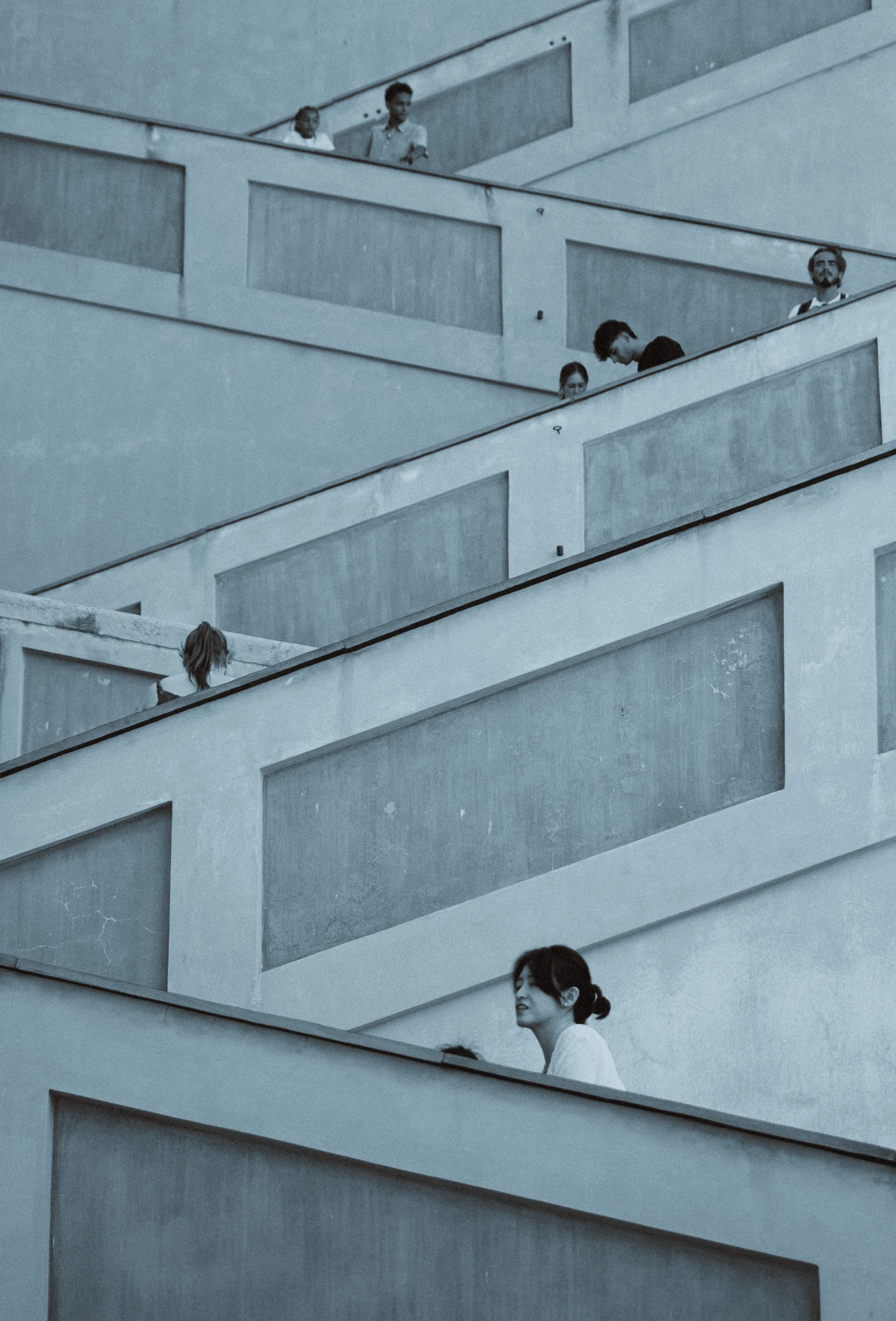 Many people walking on a zig-zag stairs