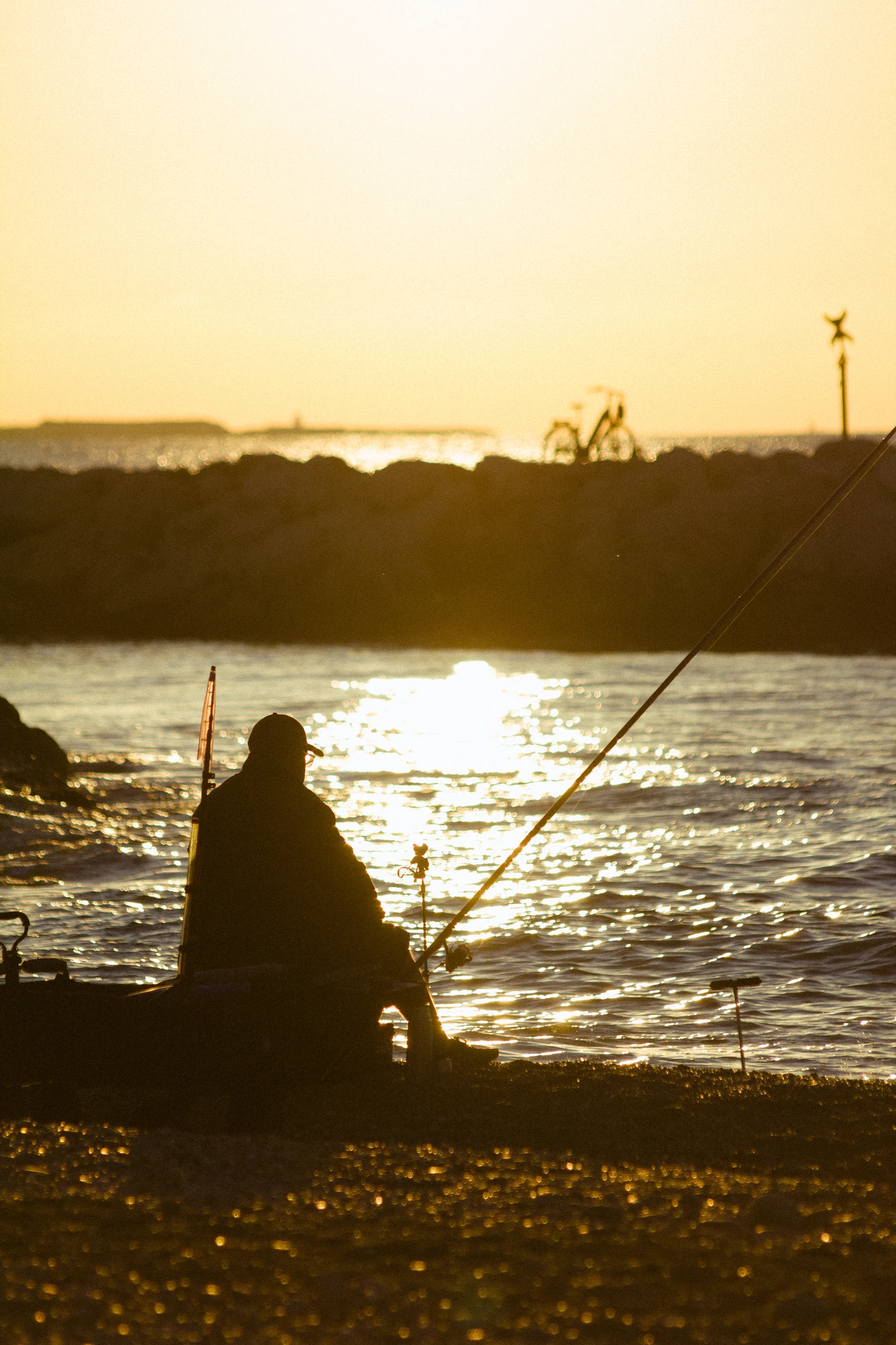 A man fishing on the beah at sunrise
