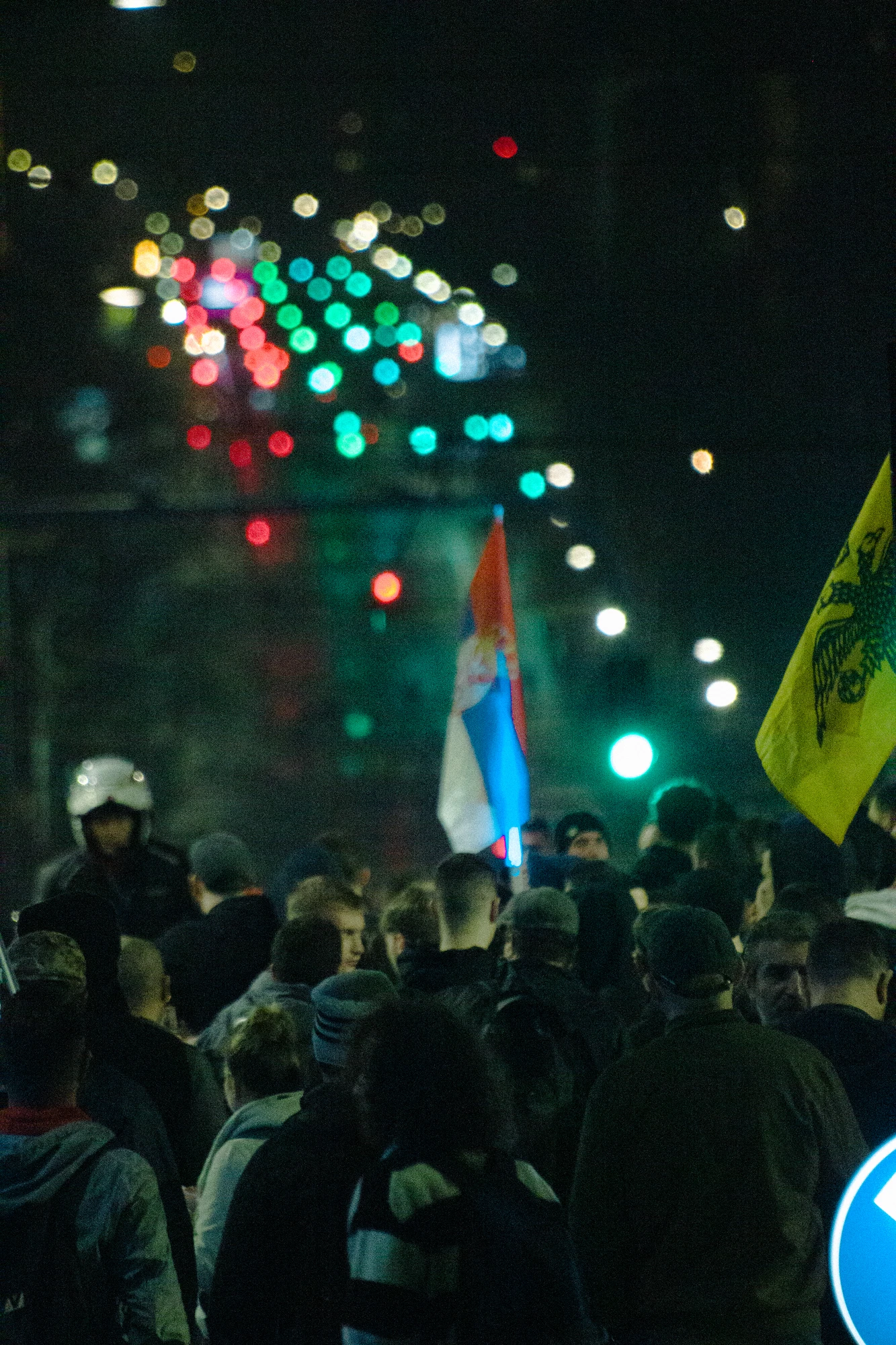 Many people standing in the street at night