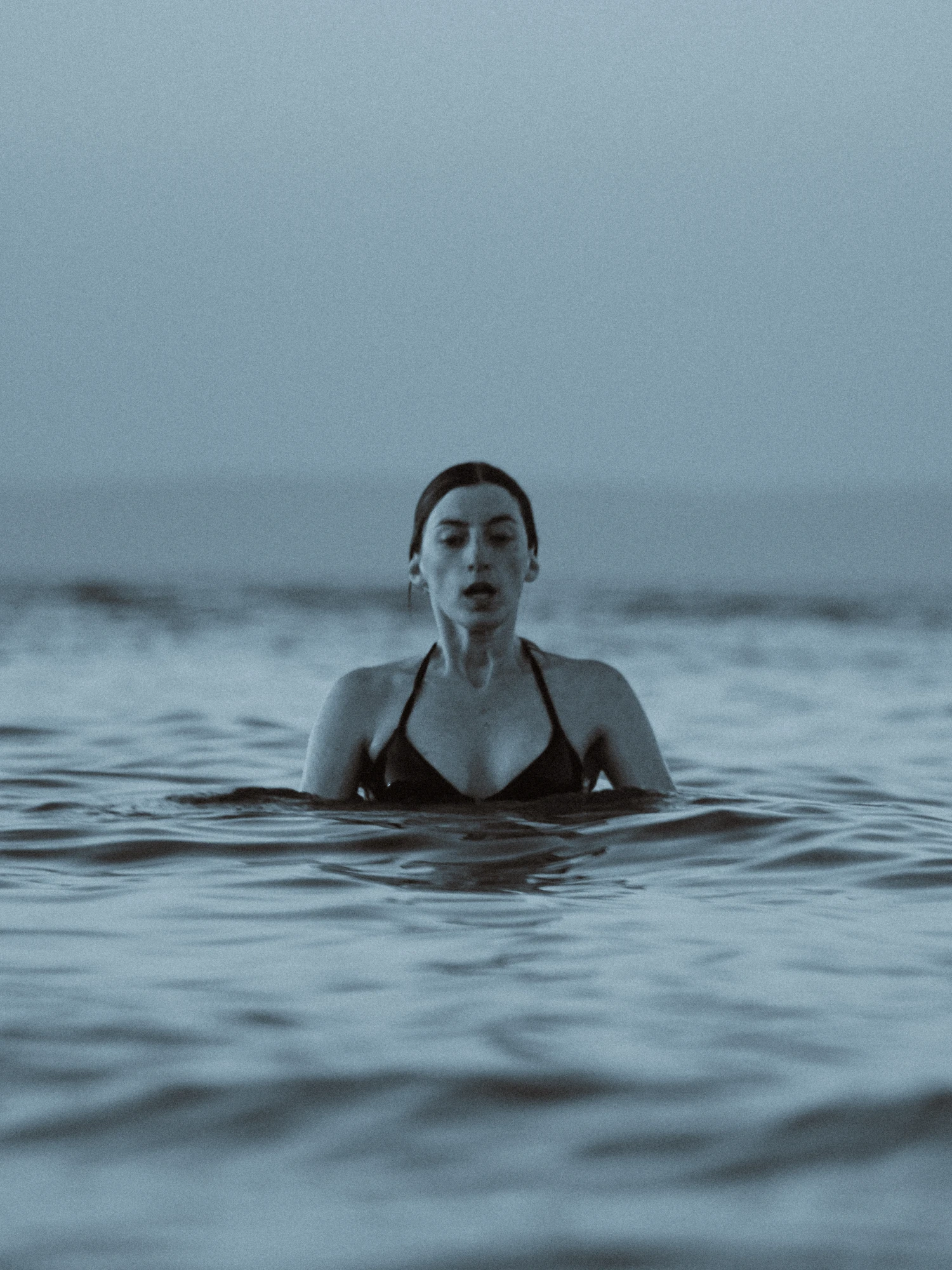 A woman taking a deep breath, about to submerge into the sea