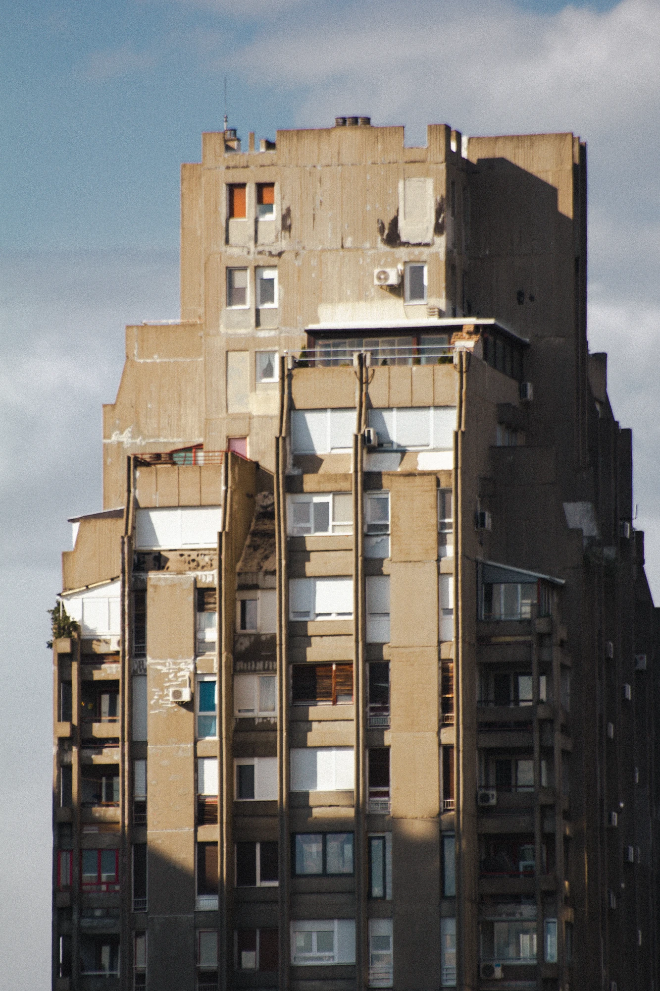 A huge concrete skyscraper with many windows