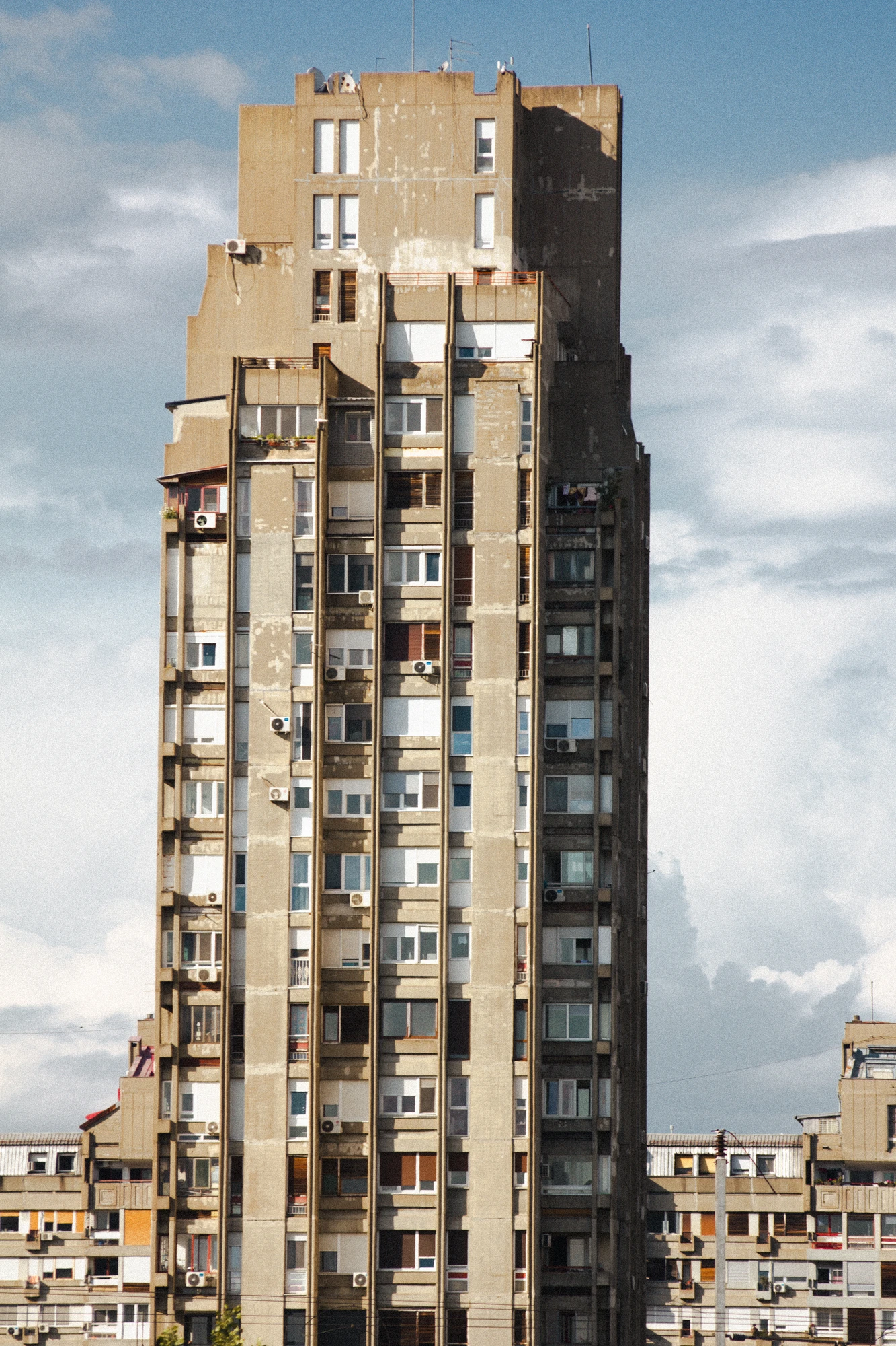 A huge concrete skyscraper with many windows