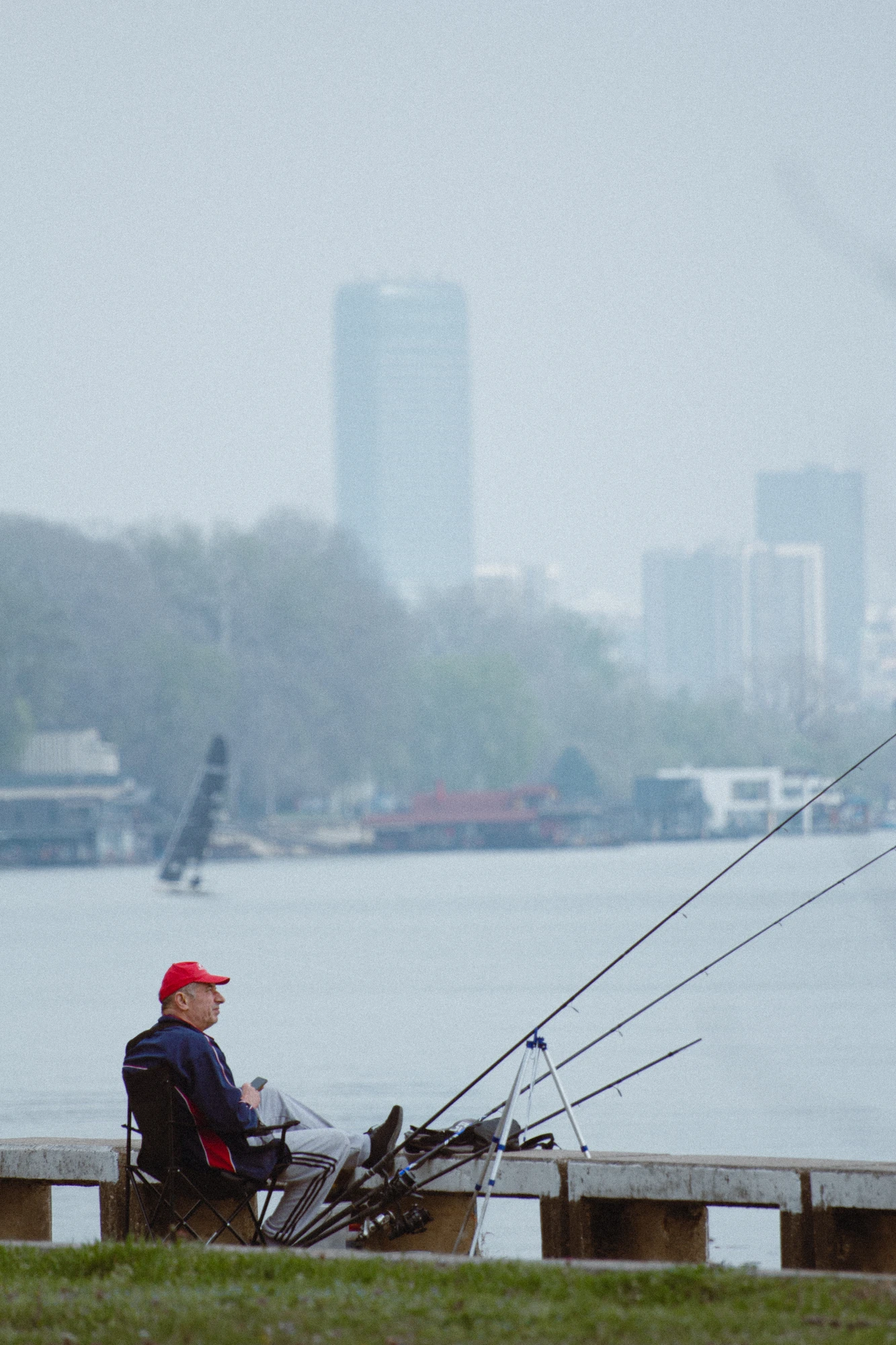 A man sitting on a bench with a fishing rod