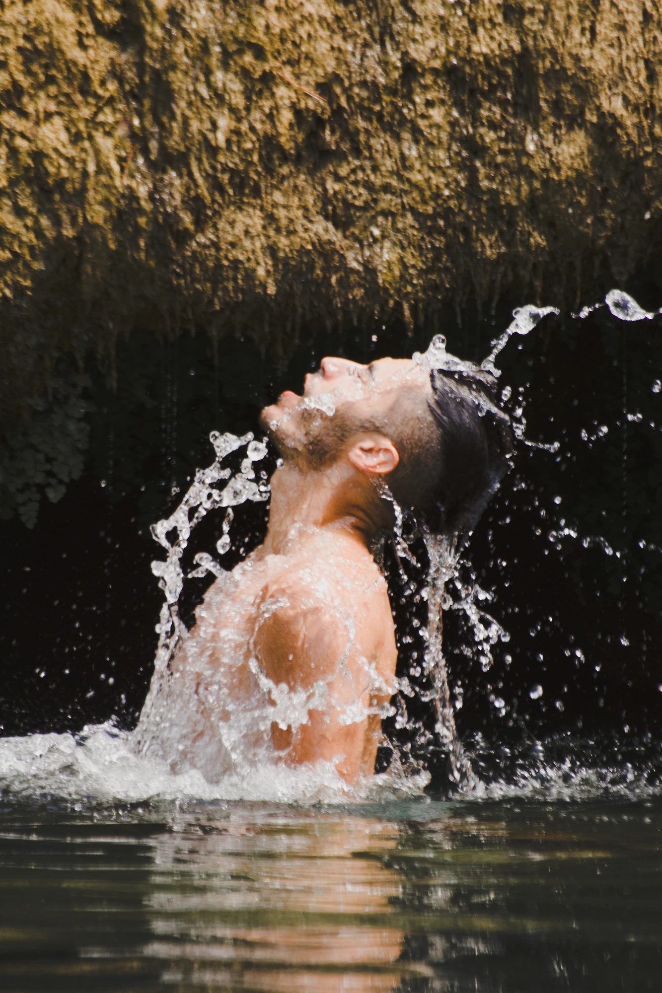 A person spectacularly emerging from the water with a splash