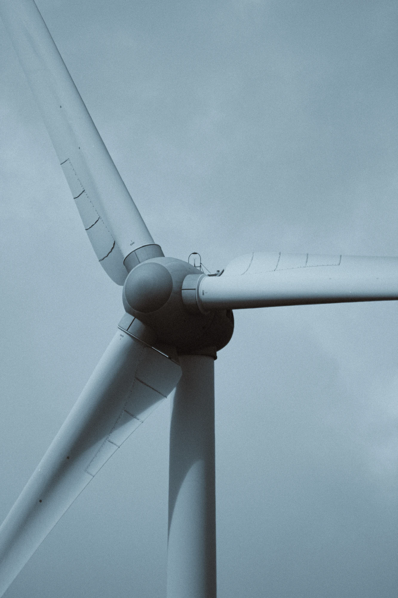 A close up of a wind turbine with a sky background