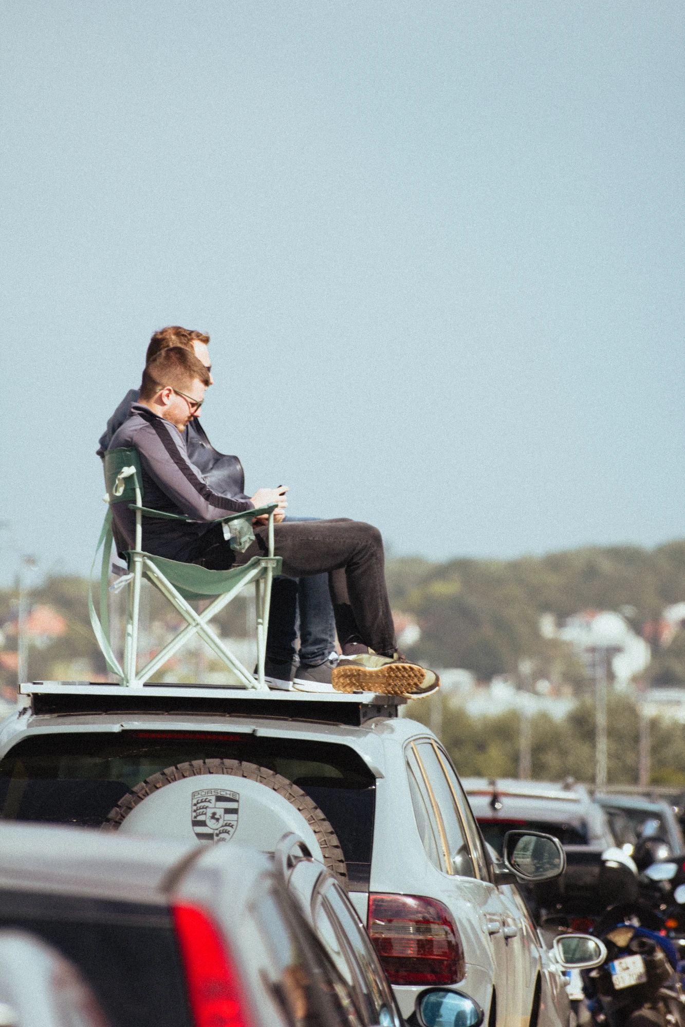 Two men sitting on a chair on top of a car
