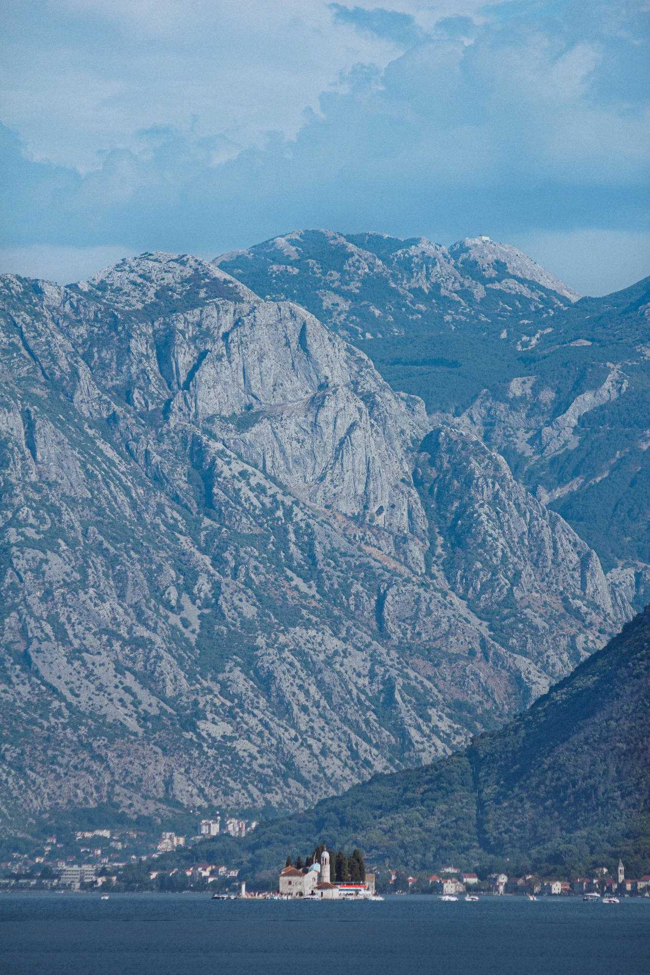 An islet on the sea with mountains in the background