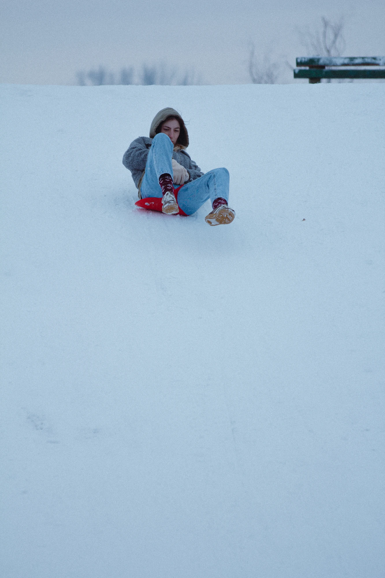 A woman sliding down a snowy hill